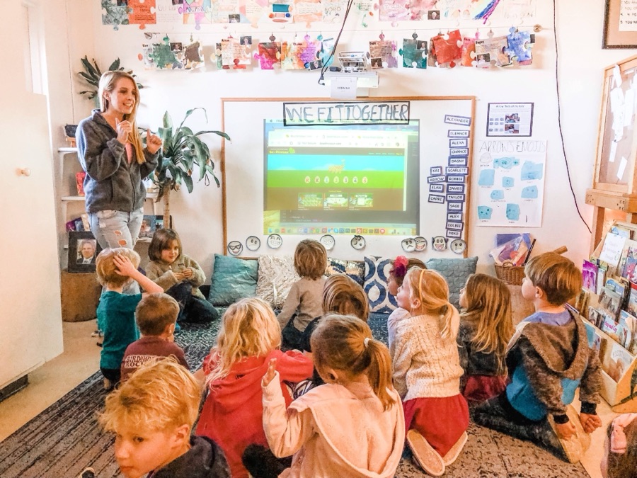Katy teaching a classroom of kids with a Be a Dinosaur game on the screen